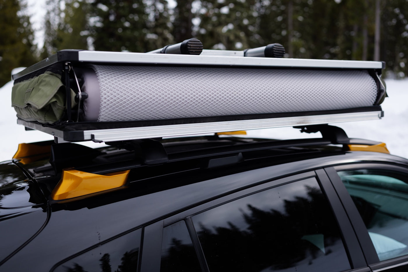 Packed rooftop tent on a black car's roof rack. A smart RV rental choice for agile snowy outdoor adventures. — photo 9
