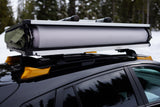 Packed rooftop tent on a black car's roof rack. A smart RV rental choice for agile snowy outdoor adventures.