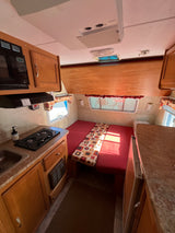 Step inside this compact RV rental! It features a functional kitchen, convertible dinette/bed, and ceiling AC unit for comfortable travel.
