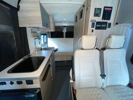 Spacious RV rental interior with modern kitchen, comfortable seating, and smart controls, perfect for travel. See this camper van's setup.