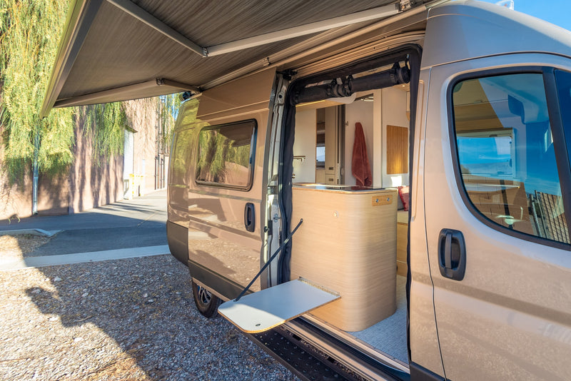  parked on gravel.|Spacious rv rental interior featuring a modern kitchen with induction cooktop — photo 4