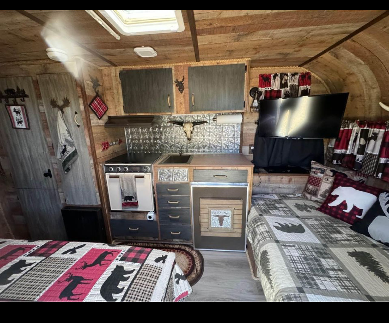  rustic RV rental! Wood-paneled interior features a plaid wildlife quilt — photo 2