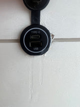 RV rental feature: A black dual USB-C and USB-A charging port mounted on a white wall panel, ready for devices.