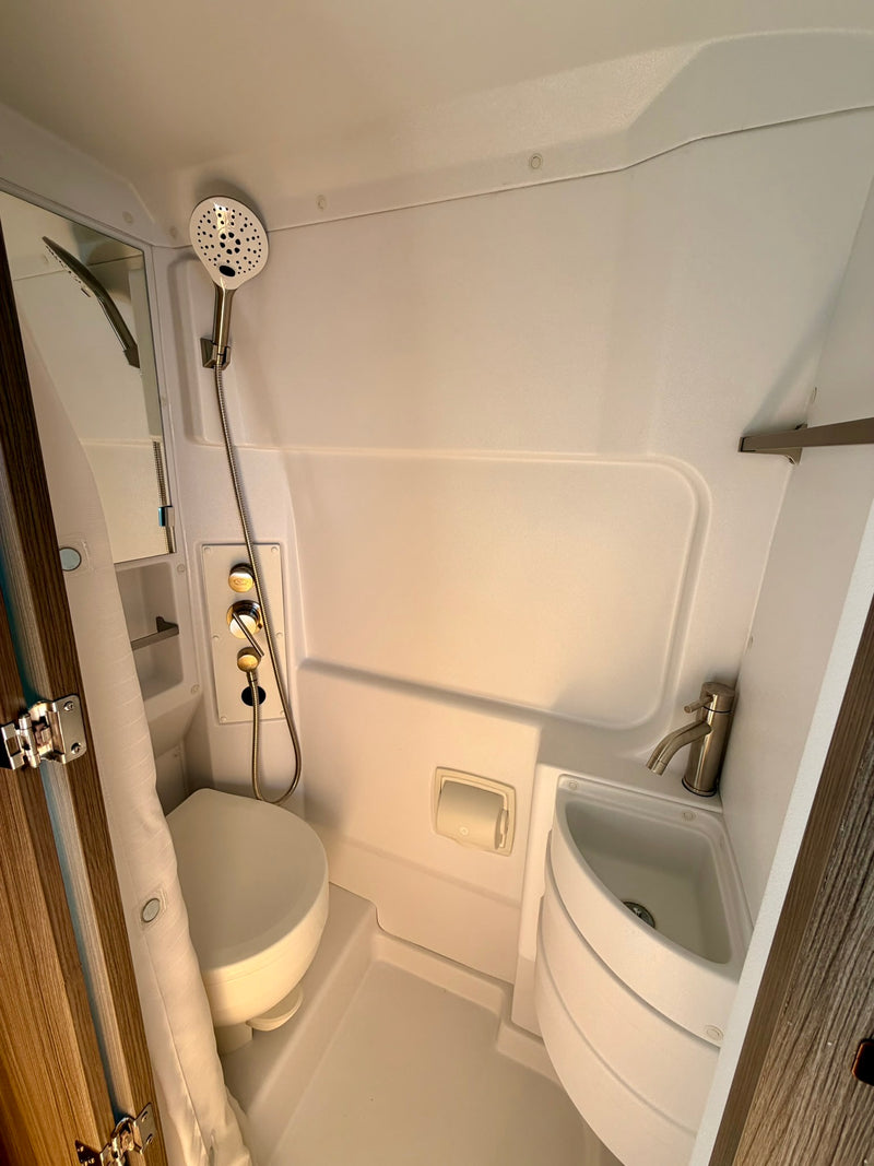  and warm lighting viewed from the open rear doors of a camper van.|An rv rental (pop-top van) under an awning by a clear spring. A campsite setup includes a picnic table — photo 7