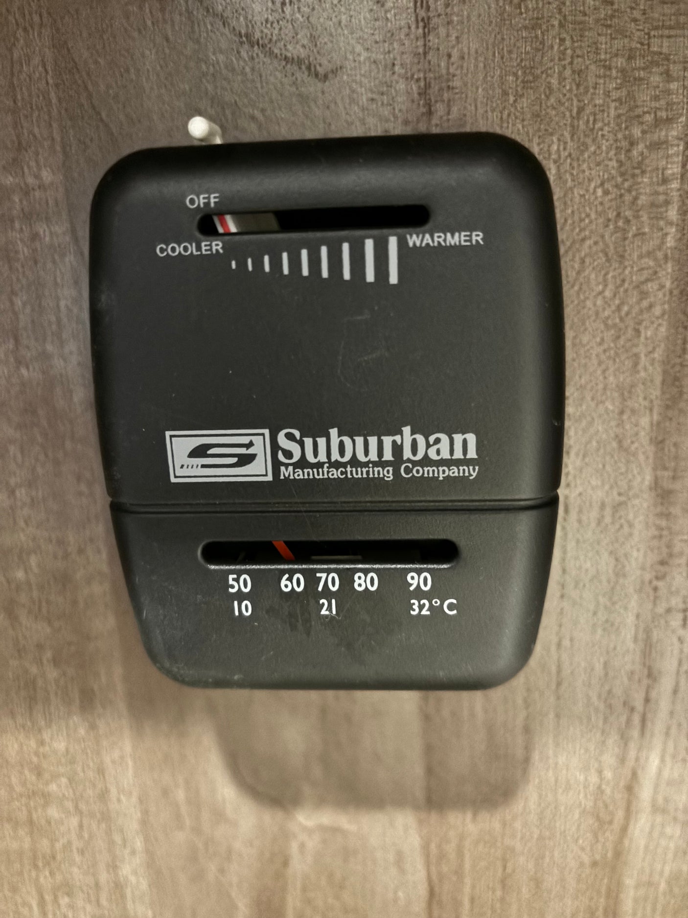 RV rental climate control: Black Suburban thermostat. Top slider is OFF. Bottom shows 60°F/16°C setting for comfort.