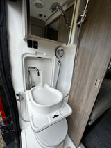 RV rental camper van interior: compact wet bath with a sink, pull-out shower, and portable toilet.