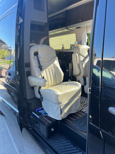 Inside this RV rental: plush, comfortable seating, a control panel, and compact kitchen area for your journey.