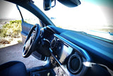 Interior view of a Toyota Tacoma truck with an open door to a vast dry landscape, ideal for travel or an rv rental.