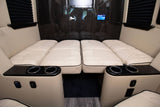 Luxurious RV rental interior with cream-quilted beds, cup holders, and charging ports, offering ultimate mobile comfort.