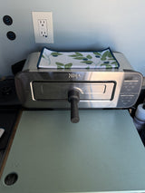RV rental's compact kitchen with a Ninja oven, a handy cutting board, and convenient USB/power outlets.