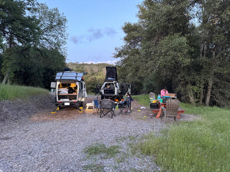 Camping with an RV rental trailer & overland SUV. Family enjoying a peaceful evening at the campsite.
