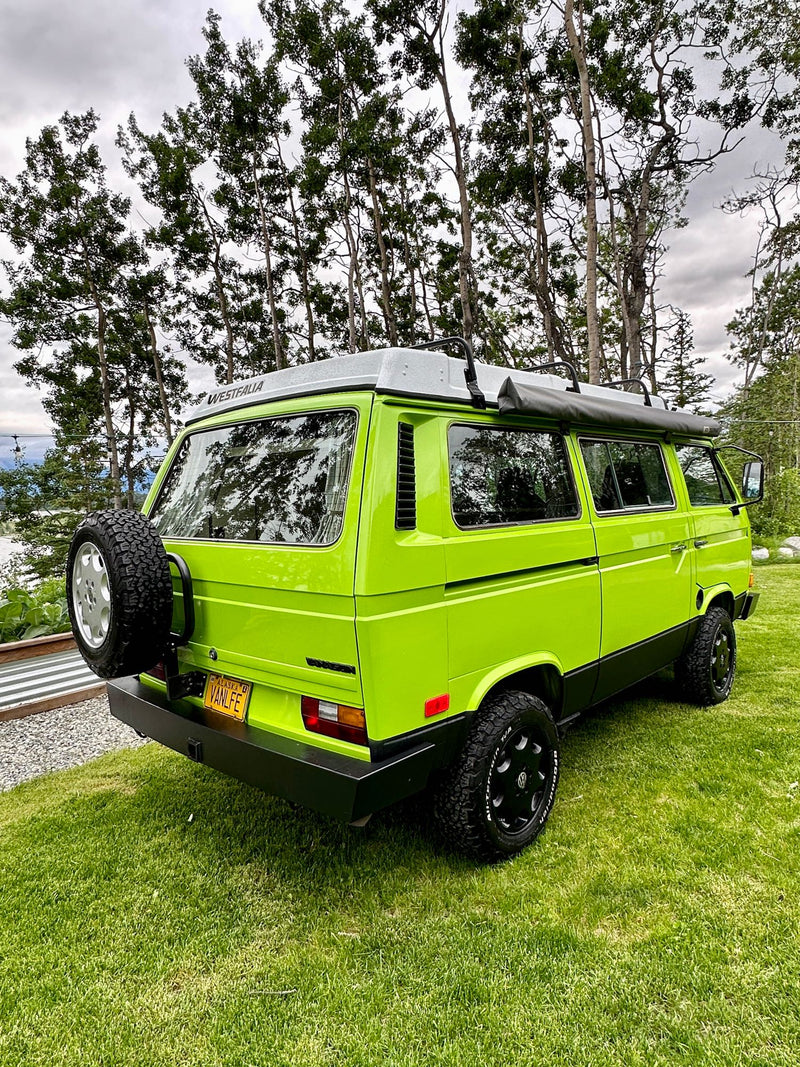  with a green adventure vehicle in the background.|Cozy RV rental: A stack of colorful travel books — photo 15