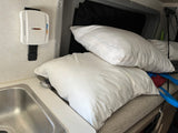 Inside an RV rental: Sink, pillows, and a wall-mounted dehumidifier for a comfortable and dry interior space.