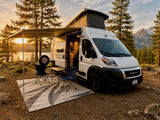 Perfect RV rental for nature lovers! White campervan under awning by a serene lake and mountains at golden hour.