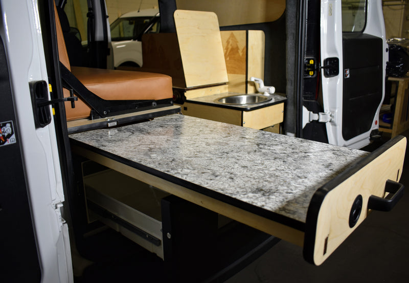 This RV rental features a pull-out counter and kitchenette, optimizing space in a modern camper van interior. — photo 5