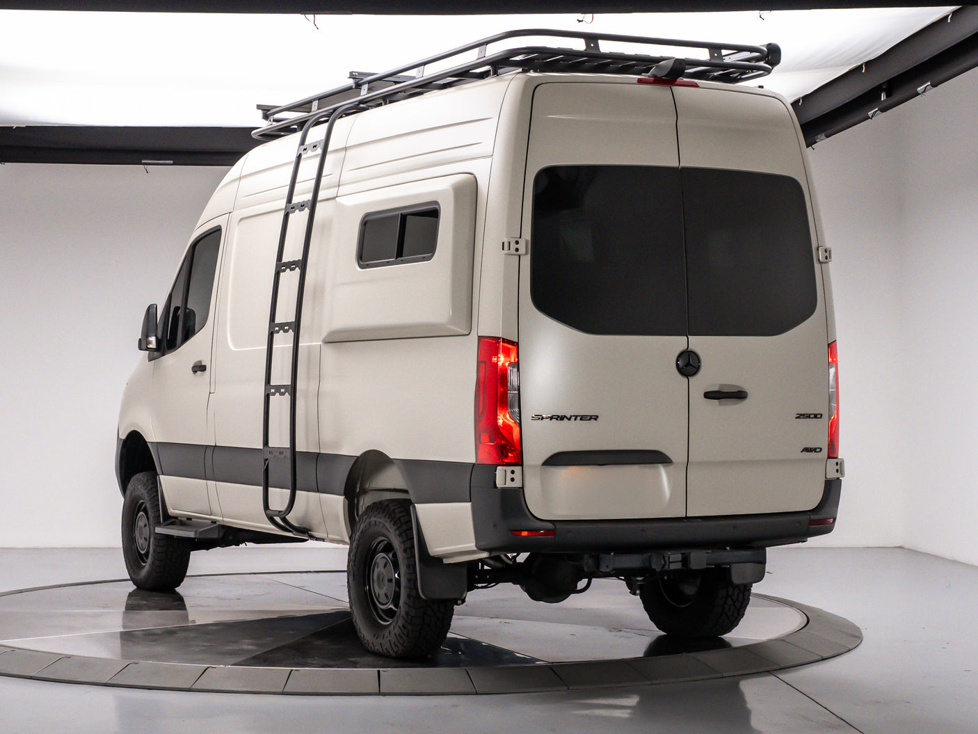 This adventure-ready Mercedes Sprinter 4x4 camper van, ideal for your next rv rental, features a roof rack & ladder.