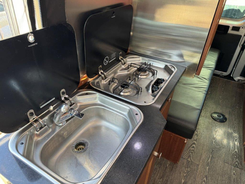  and comfortable seating.|Cozy RV rental kitchen setup featuring sinks — photo 10