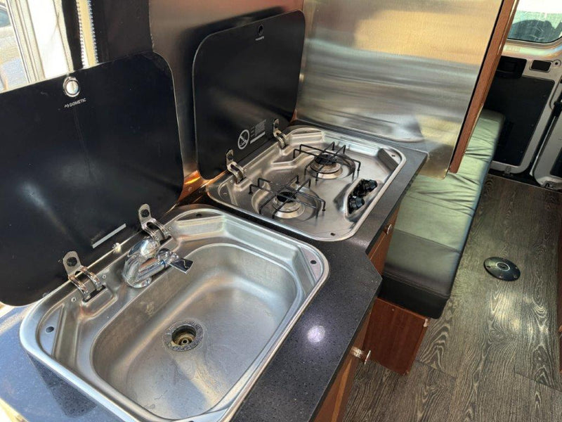  and comfortable seating.|Cozy RV rental kitchen setup featuring sinks — photo 10