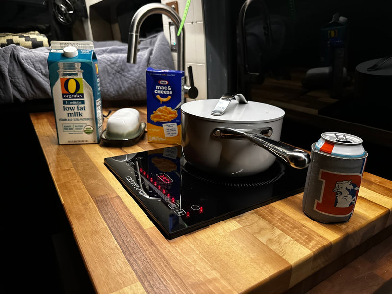Preparing a simple meal in an RV rental: mac & cheese on a Greystone induction cooktop, with milk and a Broncos can koozie. — photo 16