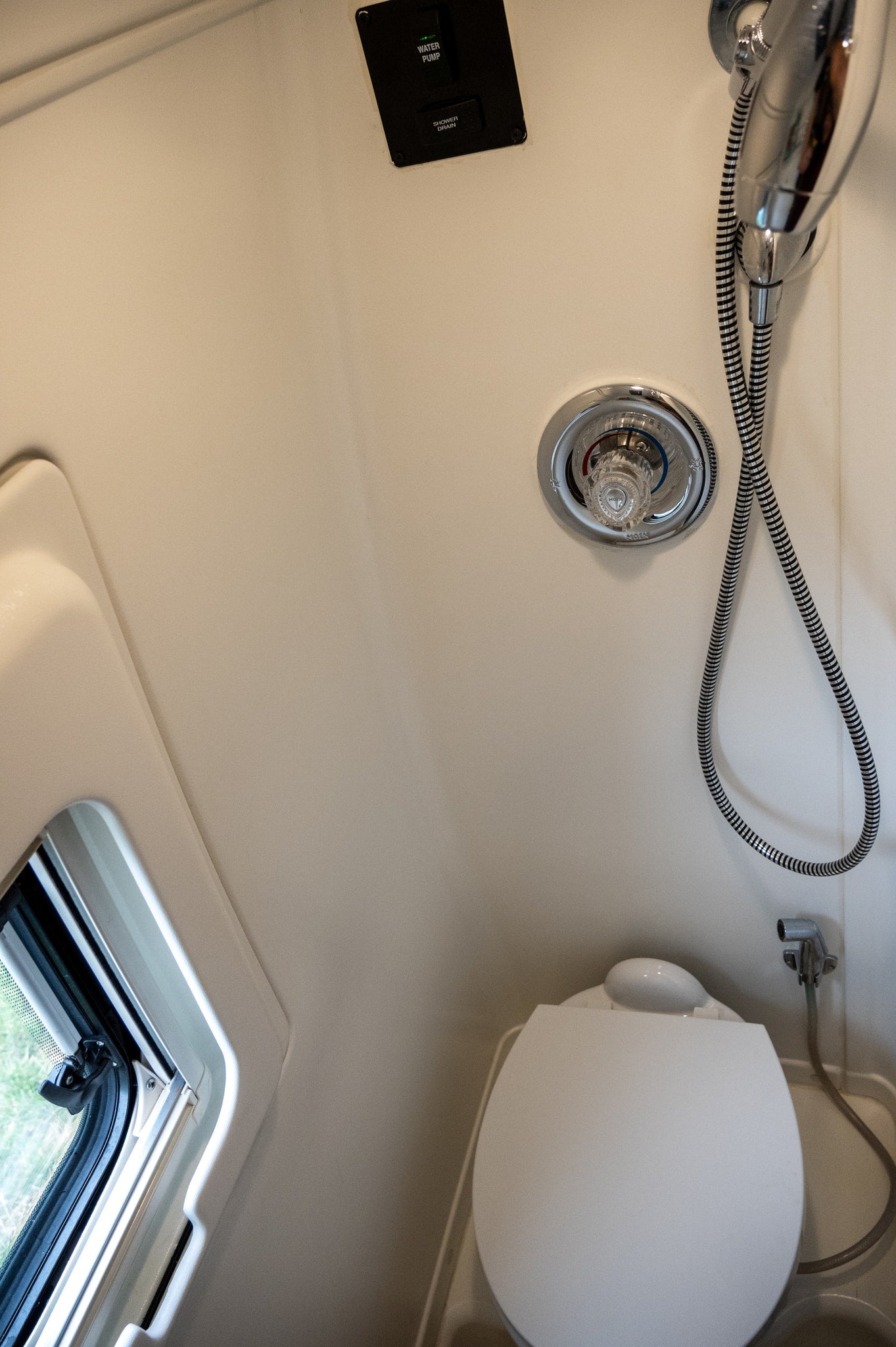  plush swivel seats and a laptop on a table form a productive mobile office with integrated system controls.|Cozy rv rental interior with twin beds — photo 10