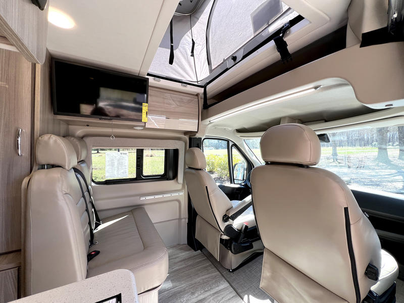  and sleek wooden cabinetry.|Experience comfort: spacious **RV rental** interior features cream-colored seating