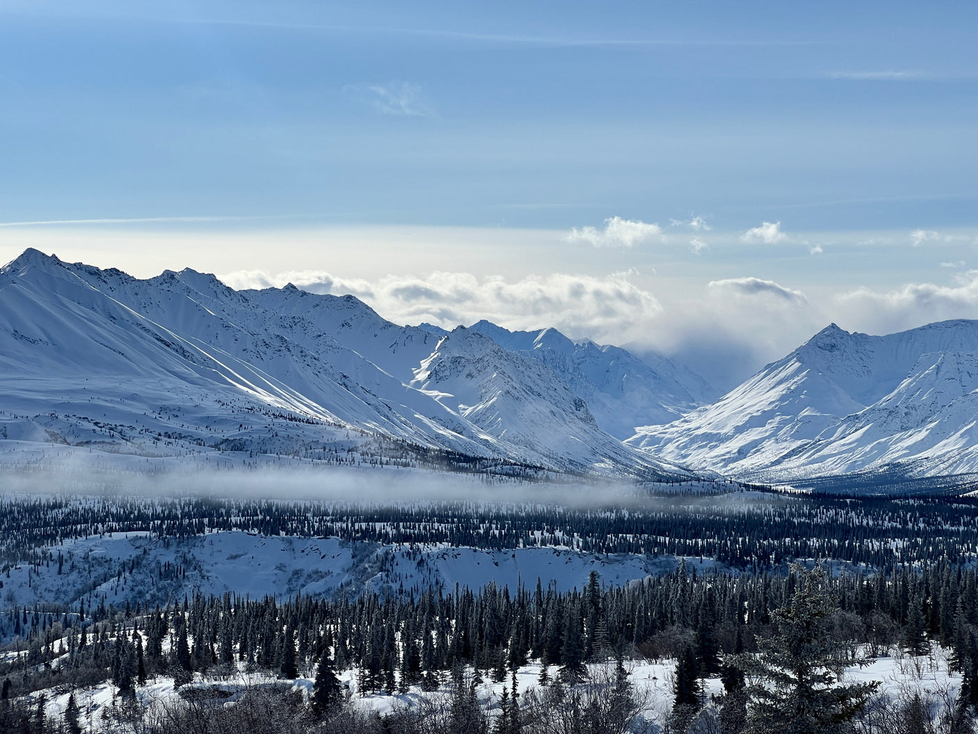 Stunning snow-covered mountains, frosted forests, and a misty valley, perfect for a winter RV rental adventure.