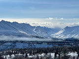 Stunning snow-covered mountains, frosted forests, and a misty valley, perfect for a winter RV rental adventure.
