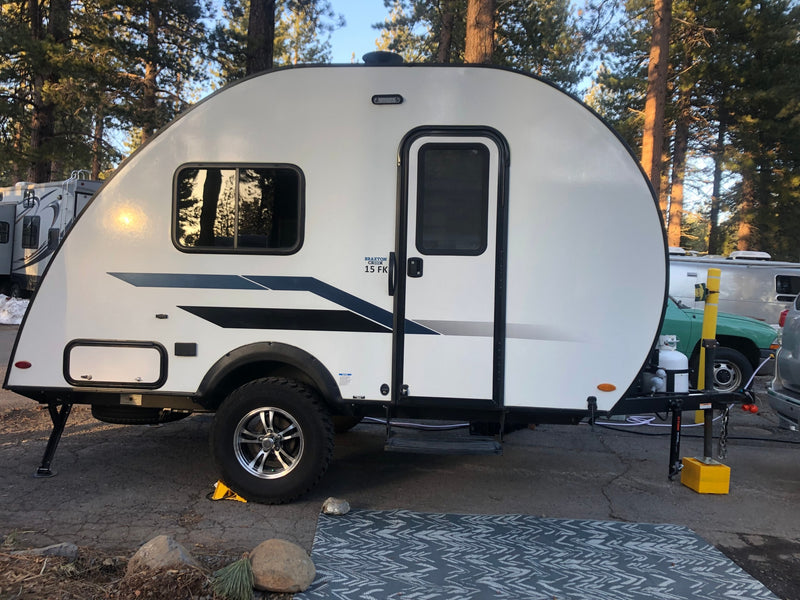  and a door with a grey hanging organizer.|RV rental kitchen setup: sleek countertop with two-burner stove — photo 8