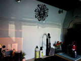 Stylish RV rental galley showcasing a functional sink, coffee corner, and decorative sun wall art.