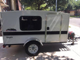 White, compact 'Runaway Navigator' RV rental, perfect for travel. Features a window, door, and chrome fender.