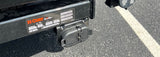 Close-up of a CURT RV rental trailer hitch and Pollak electrical connector for safe towing setup.