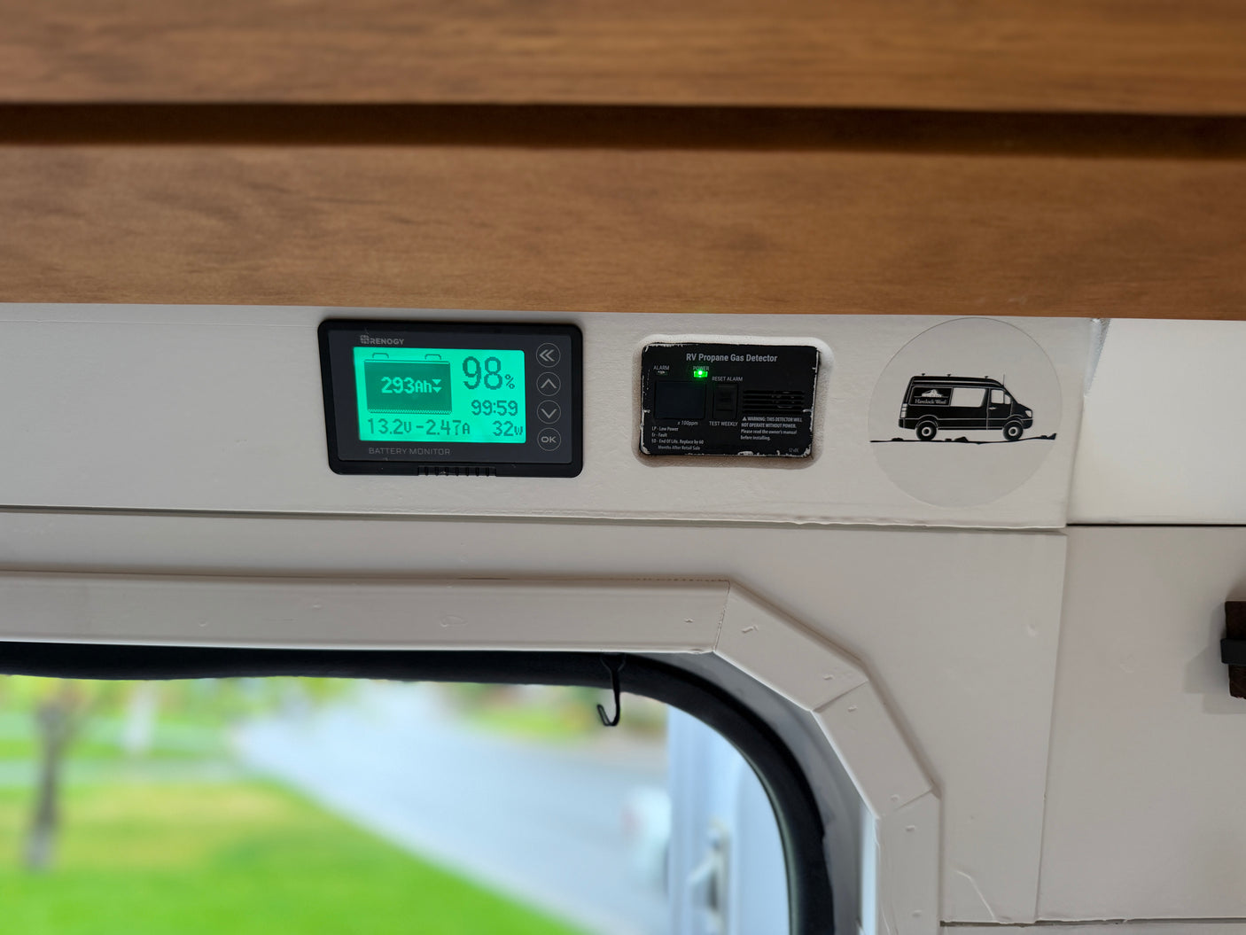 RV rental interior featuring a Renogy battery monitor at 98% charge and an active RV propane gas detector.