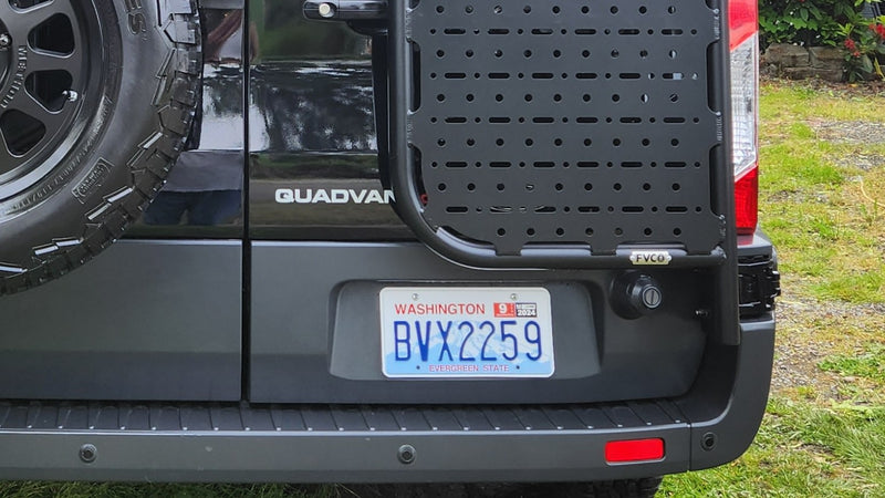 Rear view of a black custom camper van, perfect for an RV rental adventure. Features a spare tire, gear rack, and Washington plates. — photo 3