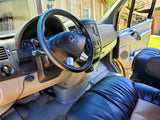 Inside an RV rental: view of the driver's cabin with Mercedes steering wheel & dashboard.