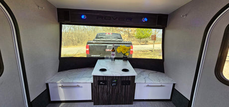 Relax in this RV rental's cozy dinette with a scenic window view. Ideal for mobile living and your next outdoor adventure.