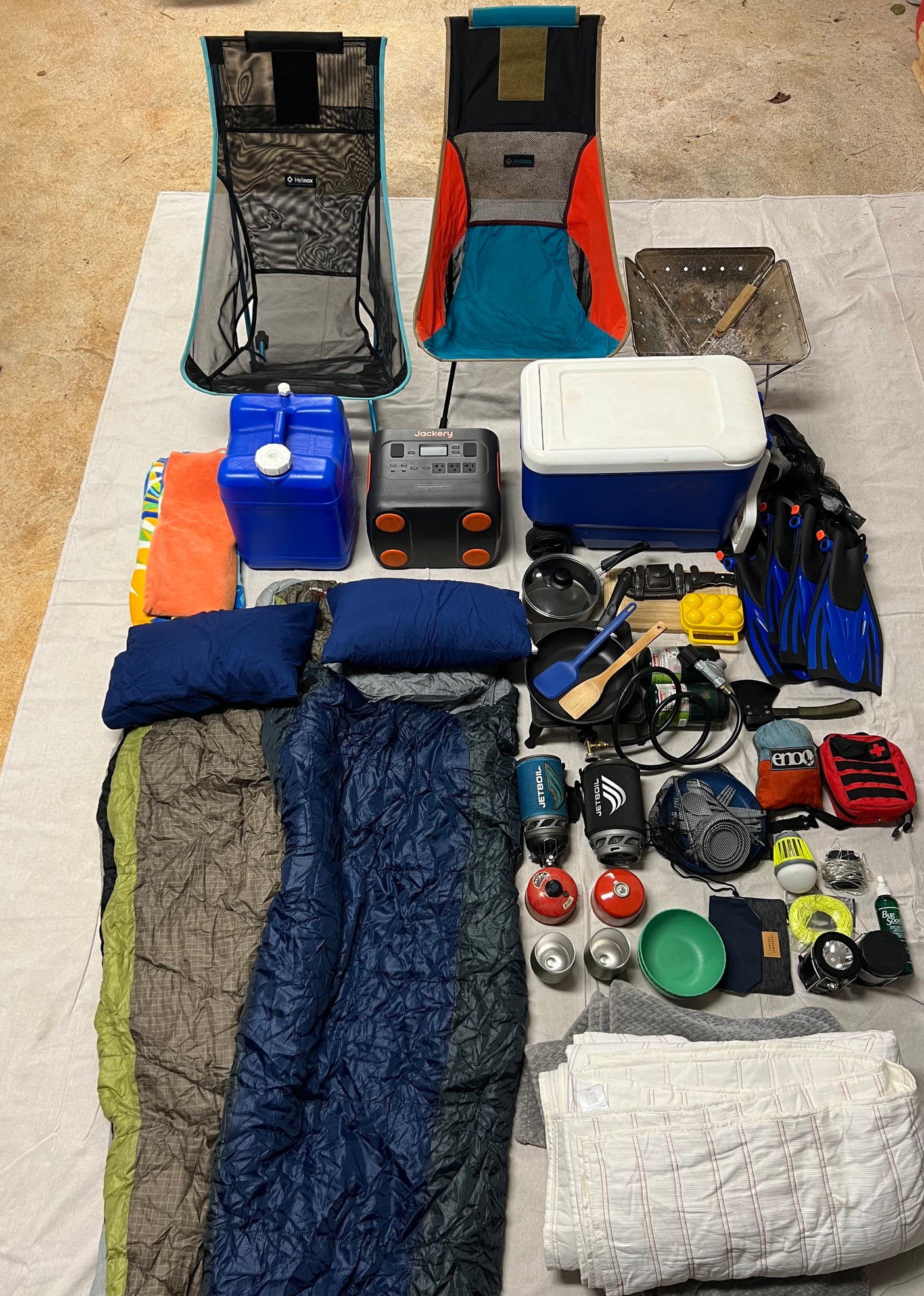 Essential gear for your RV rental adventure: camping chairs, cooking supplies, sleeping bags, and more laid out for packing.