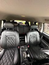 Interior of a vehicle shows black, quilted leather front seats & center console. Ideal for your next rv rental trip.