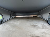 An RV rental's cozy pop-top sleeping area. A plush, light-colored bed fills the frame, surrounded by fabric tent walls.