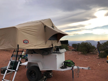 Experience scenic camping with this Tepui rooftop tent on a white overland trailer, a great RV rental option.