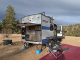 This RV rental, a Sunray Sport travel trailer, is perfectly set up for outdoor adventures with its open outdoor kitchen and camping gear.