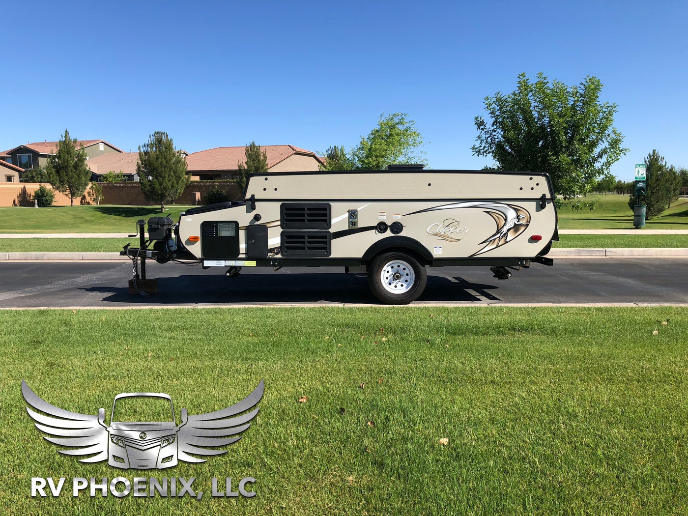 Clipper pop-up camper RV rental. Beige unit parked on asphalt, with green grass & houses in sunny background. — photo 11