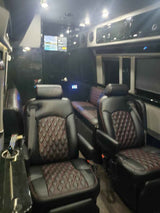 Plush black leather diamond-quilted seats and a TV fill this premium RV rental interior, ready for travel.