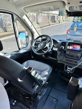 Cockpit view of an RV rental: Ram steering wheel, modern dashboard, infotainment system, and spacious interior.