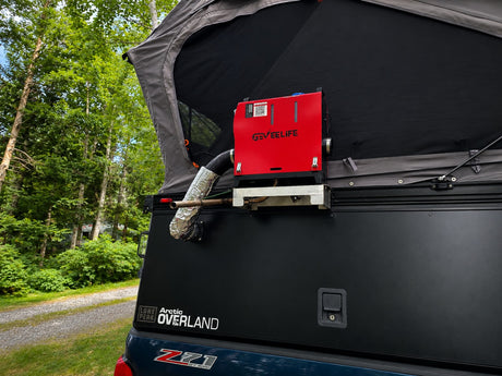 A red GEVEELIFE heater is mounted on a dark truck camper with a rooftop tent, ideal for an rv rental adventure in nature.