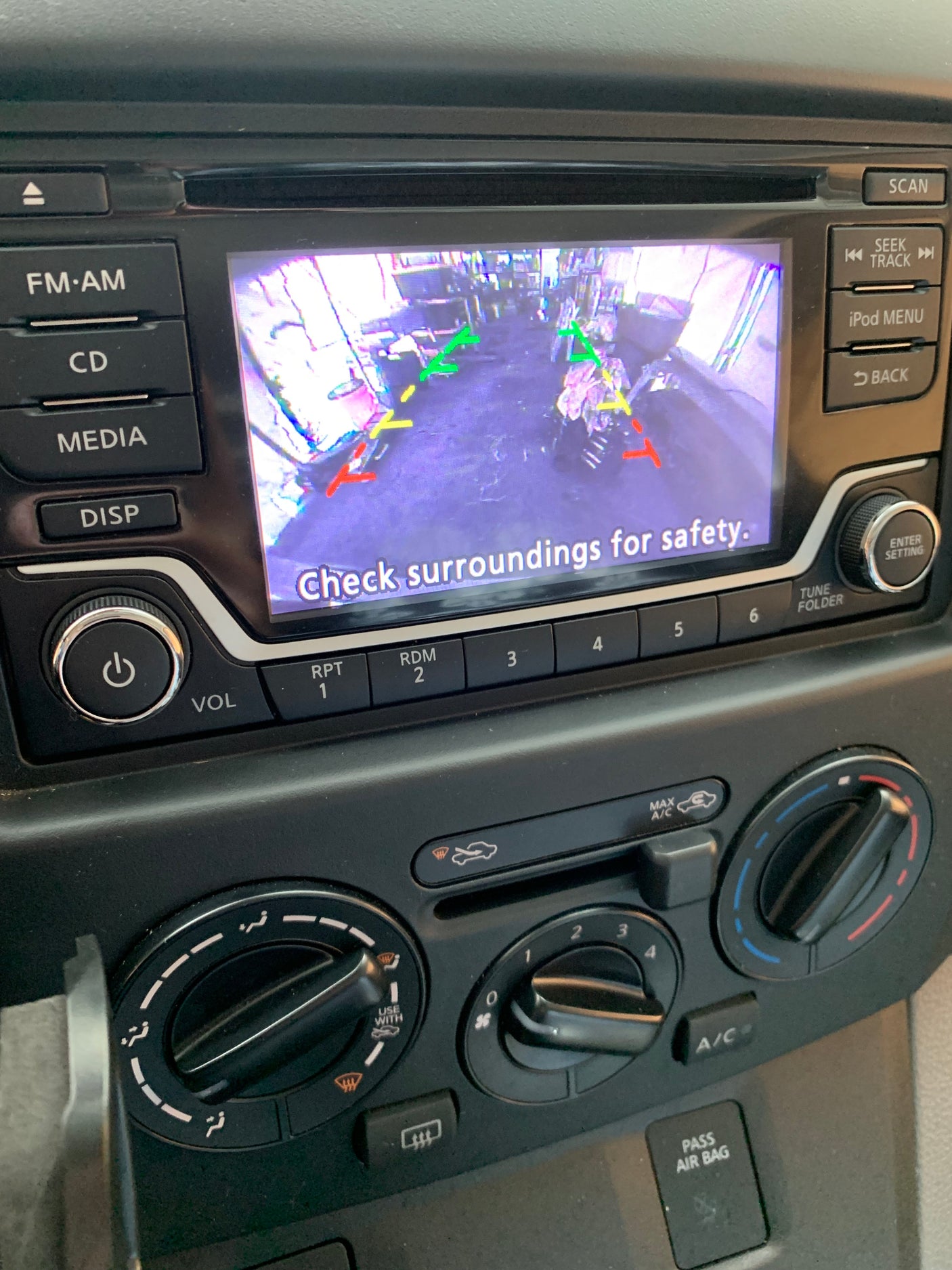 A car dashboard displays an active backup camera with "Check surroundings for safety." Essential for maneuvering an rv rental.