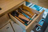 Neatly organized kitchen utensils inside an RV rental's drawer: spatulas, tongs, and silverware for your travels.