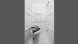 Compact RV rental wet bath with toilet, shower, and folded towels. Ideal for travel.