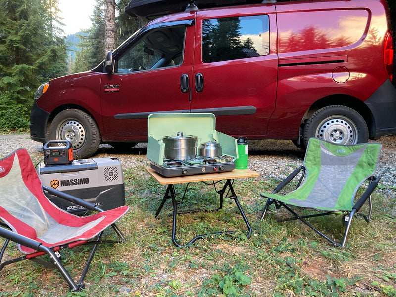 Red RV rental van with full outdoor camping setup: portable stove, table, cooler, and chairs. Perfect for van life adventures. — photo 3