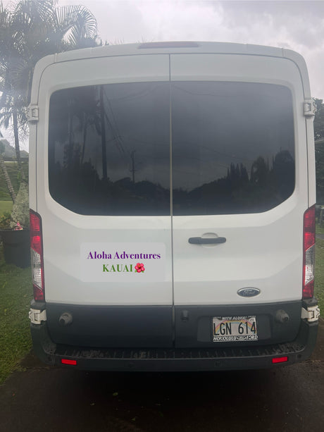 This white Ford van RV rental, with an "Aloha Adventures Kauai" sticker, features Hawaii license plate LGN 614.