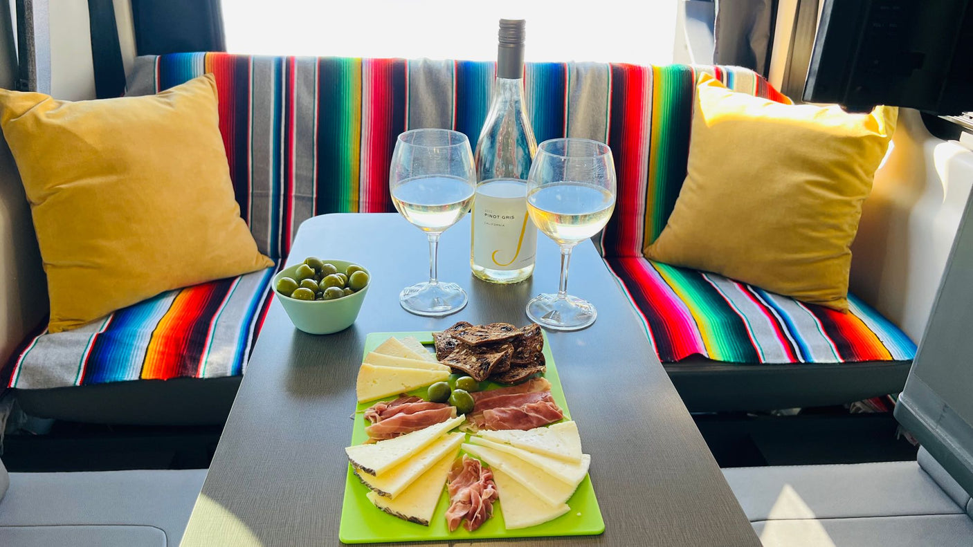 Enjoy a gourmet charcuterie & wine setup inside this vibrant RV rental. Perfect for a relaxing escape!